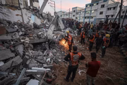 Equipes de busca e resgate participam dos esforços para resgatar civis presos sob os escombros após um ataque aéreo israelense em Khan Yunis, Gaza 
