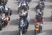 Presidente Bolsonaro acena durante passeio de moto