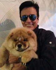 Nahim posa, sorridente, com um de seus cães