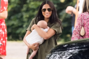 Meghan Markle com o filhote em um jogo de polo do papai Harry