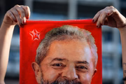 Apoiador segura bandeira com rosto de Lula