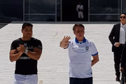 O presidente Jair Bolsonaro, de quarentena, acenou a manifestantes no Palácio do Planalto