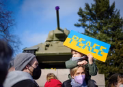 Participantes protestam contra a guerra na Ucrânia com uma placa com a inscrição "Paz" no memorial aos soldados soviéticos mortos na Segunda Guerra Mundial em frente a um tanque soviético T34