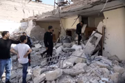 Palestinos olham prédio fortemente danificado em um ataque de foguete depois que as forças israelenses invadiram a cidade de Abu Dis, em Jerusalém