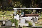 Sepultadores usam máscaras para transitar no cemitério