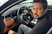 Gustavo Arona posa para as redes sociais em um carro