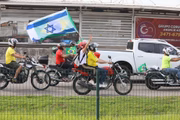 Motociclista segura bandeira de Israel durante passeio