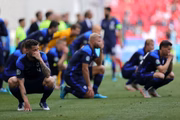 Companheiros e adversários angustiados em campo