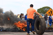 Os manifestantes espalharam blocos de concreto e queimaram pneus na via, para interditar a passagem de veículos