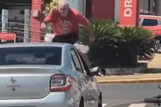 Após ter a motocicleta derrubada, o piloto subiu no capô do carro e pulou sobre o veículo