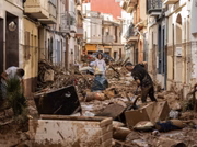 Moradores limpam uma rua coberta de lama e detritos depois que uma enchente atingiu grande parte do país em 31 de outubro de 2024, no município de Paiporta, em Valência, Espanha
