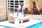 Chauncy Glover posa com a camisa aberta à beira da piscina