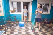 Adrieli Anequini ao lado do marido Vagner limpando a casa invadida pela água
