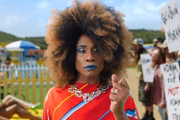 Billy Porter marchando em frente a demonstradores anti-LGBT