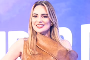 Rachel Sheherazade posa de look marrom e sorridente na coletiva de seu programa na Record