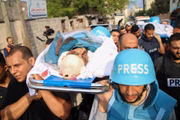 Amigos e parentes carregam os corpos dos jornalistas palestinos Muhammad Sobh e Saeed Al-Taweel, que foram mortos durante ataques aéreos israelenses